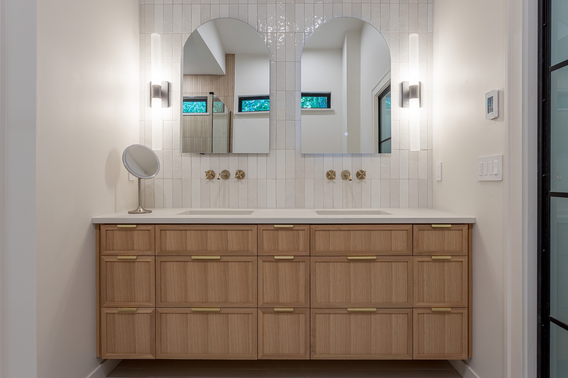 Custom bathroom remodel with extensive cabinetry and custom tile and faucets extending from the wall
